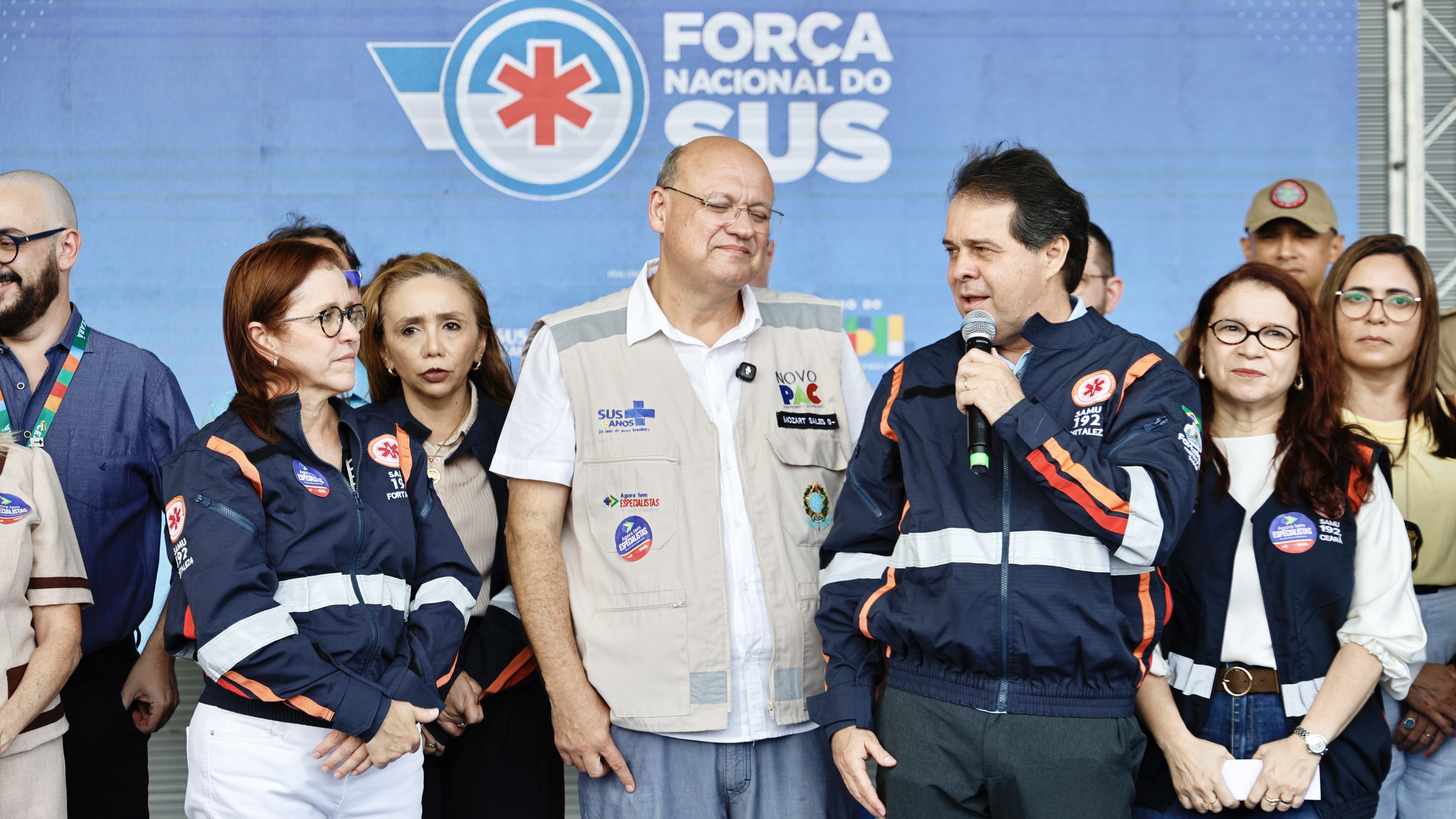prefeito falando ao microfone no palco do evento